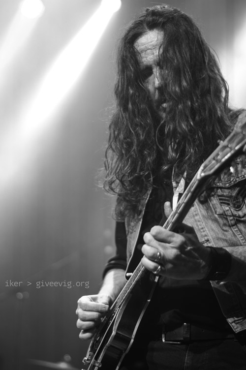 Fotografía de Txus con sus pelos tapándole la cara, mientras toca la guitarra